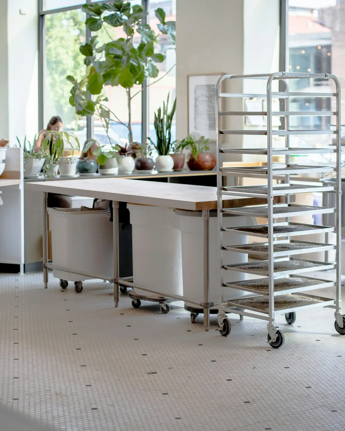 Stainless-steel prep tables, a tray rack and equipment exteriors in a commercial kitchen